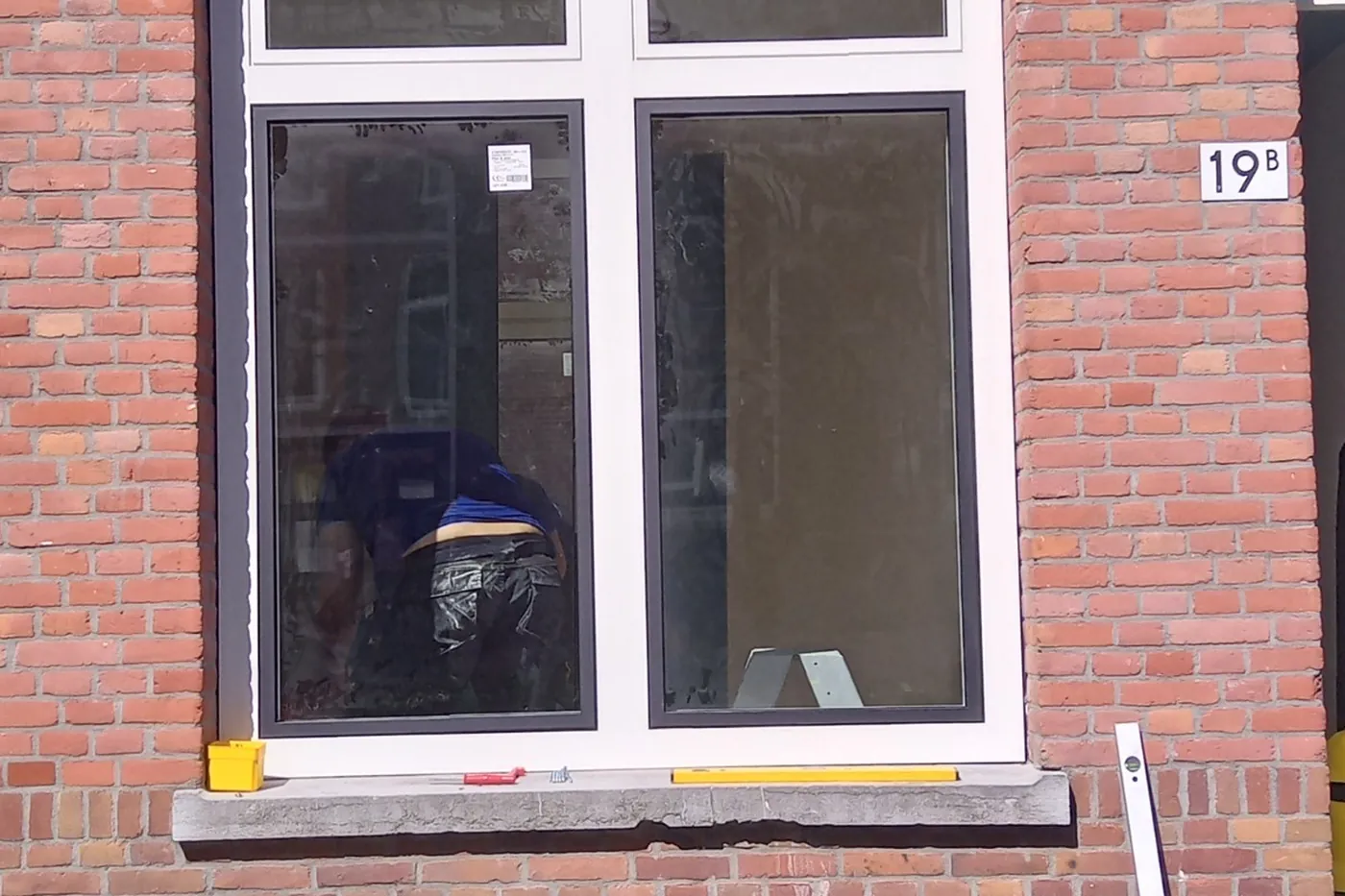 Detail van een nieuw antracietgrijs kunststof kozijn in een bakstenen gevel