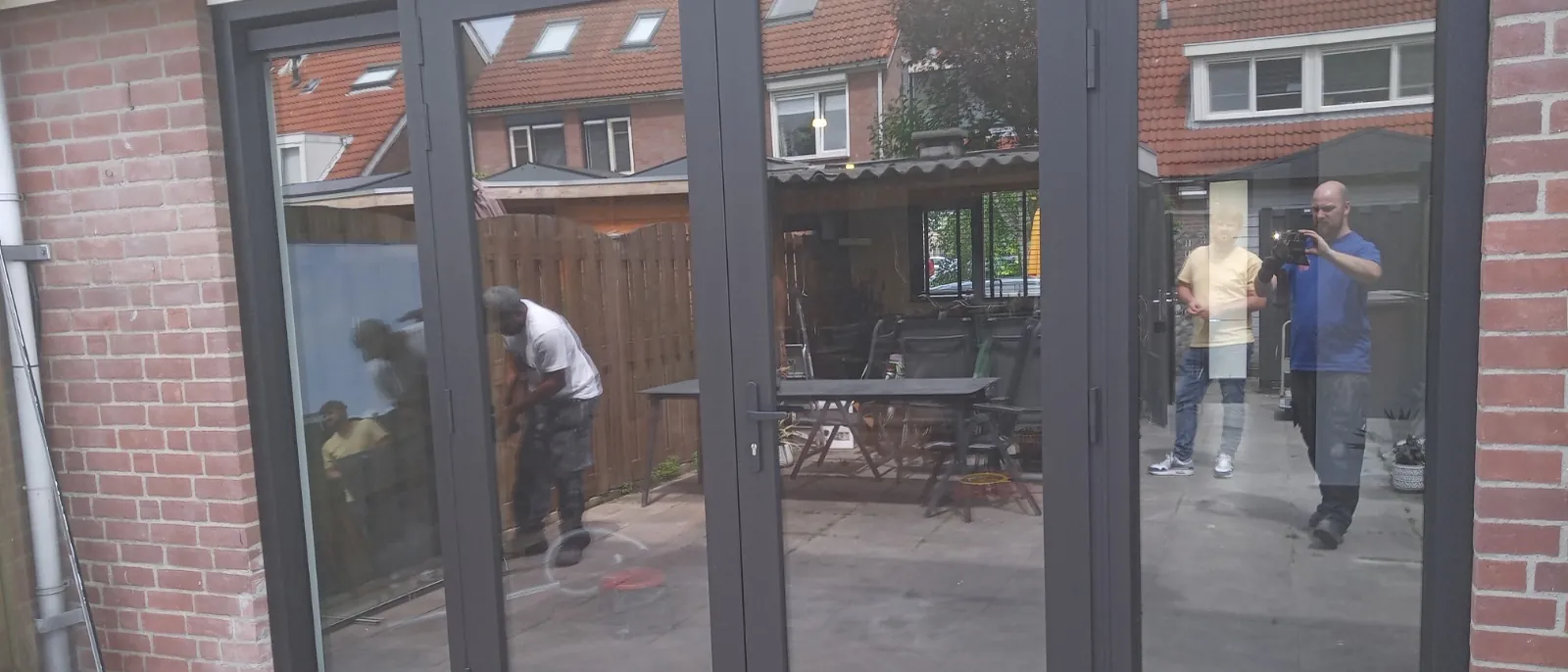 Een door Feniks Kozijnen geplaatste pui, met de eigen monteurs nog aan het werk